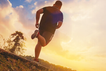 Wall Mural - Silhouette of overweight man running sprinting on road. Fat man runner jogging at outdoor workout. Exercise concept for weight control.