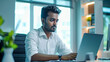 © Graphic Master - South Indian corporate man sitting at a desk, doing job on laptop