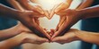 © Imaginary Capture - A group of people holding hands in a heart shape, the concept showing diversity collaboration