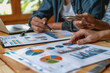 © PHAISITSAWAN - Business team meeting to analyze data charts for marketing plans and office profits.