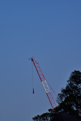 Close-up of construction crane with clear sky in background. Construction scene and city development. 