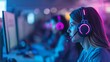 © Rattanathip - Focused female gamer wearing headphones, playing a video game on a computer in a dark room with colorful lights.
