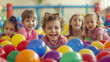 © 2B - A group of happy smiling boys and girls in a pile of colorful balls.