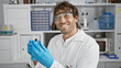 © Krakenimages.com - Smiling scientist with beard and glasses holding test tube in laboratory.