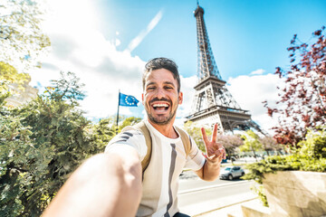 Happy tourist taking selfie picture in front of Eiffel Tower in Paris, France - Travel and summer vacation life style concept