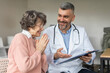 © Home-stock - Assistance male doctor explaining results of examination to senior elderly woman after treatment and checkup. Caregivers smile to encourage and care for patient