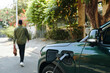© DragonImages - Man leaving his electric car charging after ride