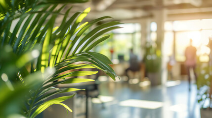 Wall Mural - blurred background of staff in a contemporary office surrounded by greenery and sunlight, reflecting