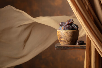 Poster - Dried medjool dates in wooden dish on a brown background.