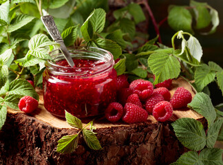 Wall Mural - Jar of raspberry jam and fresh berries with leaves.