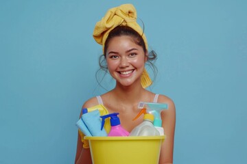 Wall Mural - A woman holds a bucket filled with various cleaning supplies, ready for use