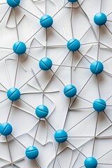 Poster - A flat lay of blue pills connected in a intricate network on a light background by white lines forming symmetrical arrangements and geometric patterns

