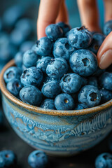 Poster - Close-up of a handful of blueberries being added to a smoothie bowl,