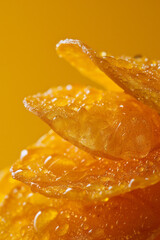 Poster - A macro image of a chip with a honey mustard glaze against a solid yellow background,