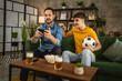 © Miljan Živković - Two excited men friends brother use phone to watch football match home