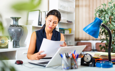 Business woman prepares and signs important documents in the office