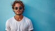 © Maxim Borbut - An attractive man in a white t-shirt and sunglasses on a blue background