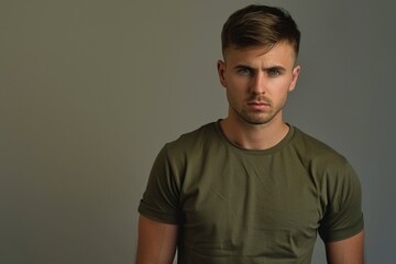 Wall Mural - A man wearing a green t-shirt stands posing for the camera, simple and casual