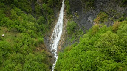 Wall Mural - waterfall in a green gorge in the spring mountains of the Caucasus, aerial view