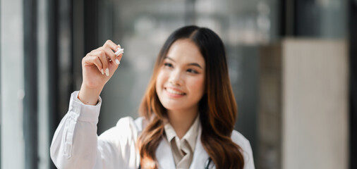 Wall Mural - A woman in a white lab coat is holding a marker and drawing on a white board. She is smiling and she is enjoying herself. Concept of creativity and fun