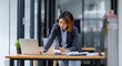 © David - Asian Businesswoman Using laptop computer and working at office with calculator document on desk, doing planning analyzing the financial report, business plan investment, finance analysis concept.
