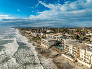 Aerial view of Carlsbad promenade, oceanside villas, holiday rentals with cloudy sky