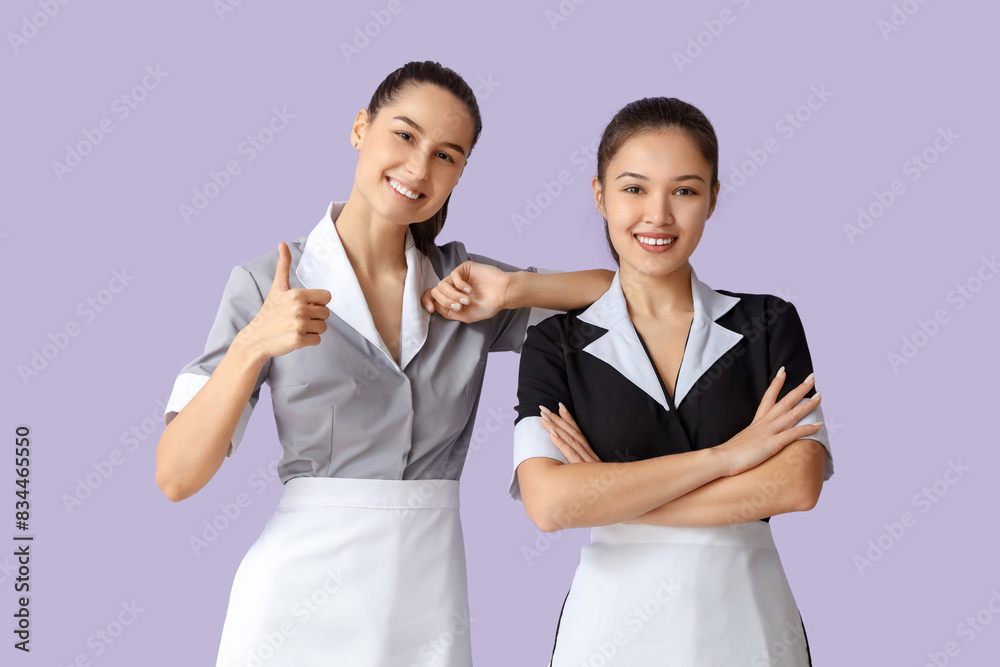 Young chambermaids on lilac background