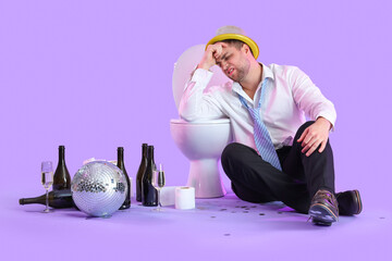 Poster - Drunk young businessman sitting near toilet bowl after party on lilac background