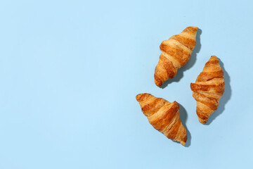 Wall Mural - Tasty croissants on blue background