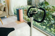 © DragonImages - A detailed view of a stationary bike in a bright living room with yoga mats and plants by the window