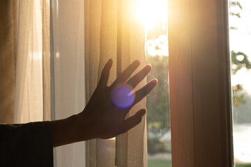 Wall Mural - The woman was at the window in the bedroom. She opened the curtains on the window. In the morning and she looks at the view of mountains and trees at sunrise