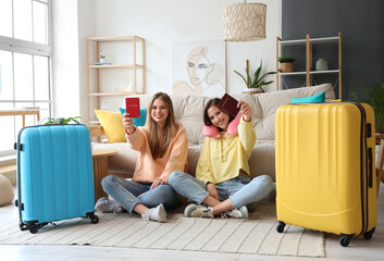 Sticker - Female friends with passports and suitcases sitting on floor at home