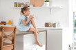 © Pixel-Shot - Cute little girl drinking water on table in kitchen