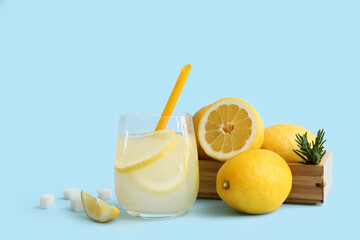 Glass of fresh lemonade with sugar and rosemary on blue background