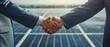 © Seksan - Businessmen negotiating a deal on solar panel projects, shaking hands to confirm collaboration Emphasis on environmental cooperation and green energy