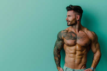 Sticker - A muscular man stands in front of a blue wall. He is posing for a picture, and his chest is showing