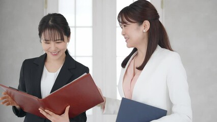 Poster - オフィスで会話する二人のビジネスウーマン
