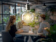 © Who is Danny - People in a blurry meeting room under a clear, illuminated light bulb, symbolizing a brainstorming or idea concept. Generative AI