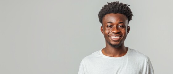 Wall Mural - Smiling Young Man in White T-Shirt on Light Gray Background - Studio Shot of Happy African American Male Model