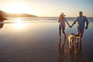 Wall Mural - Ocean, sunset and couple with dog in nature for outdoor adventure, travel or summer holiday together. Man, woman and holding hands with furry pet at beach for love, support and vacation in California