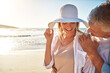 © Reese2000/peopleimages.com - Senior, happy couple and beach with sunset for love, embrace or bonding together in nature. Man, woman or lovers with smile in joy for outdoor sunshine, summer or holiday by water, sea or ocean coast