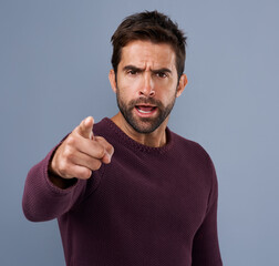 Poster - Studio, serious and portrait of man, pointing and accountability for you, choice and recruitment. Blue background, face and person with hand, gesture and opinion for promotion and hiring in England
