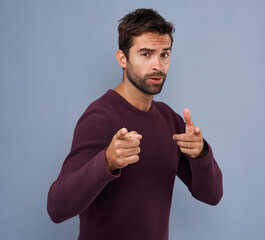 Poster - Studio, pointing and portrait of man, fashion and choice for clothes, gesture and jersey for winter. Blue background, mockup and banner for person with cardigan, cool and proud with organic cotton