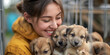 © Ice Cream Paradise - Volunteer woman smiling with a puppy at a shelter for shelter dogs