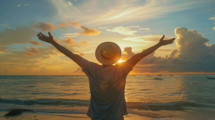 Happy man raising arms up enjoying sunset on the beach. Delightful traveler standing with hands up looking morning sunrise