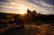 © Wirestock - A  couple embracing while looking at the Alcazar of Segovia  during sunrise