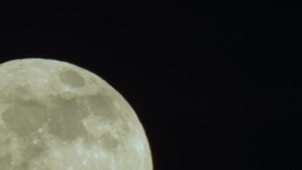 Wall Mural - Extreme Close-up of Full Moon Rising from Lower Left Corner of Frame