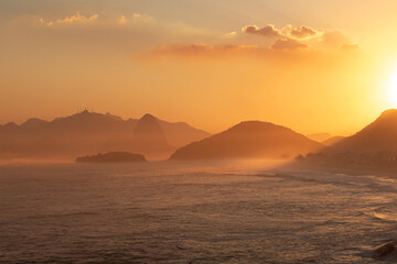 Sticker - a view of a sunset with mountains in the distance and ocean