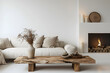 © john - Wood slab coffee table, sofa with beige pillows near fireplace against white wall with copy space. Scandinavian home interior design of modern living room.