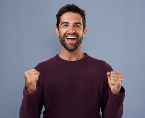 Wall Mural - Portrait, fist and happy man in studio with celebration for achievement, target or reaching goal on blue background. Excited, scream and male person for success, victory or lotto winner on mockup